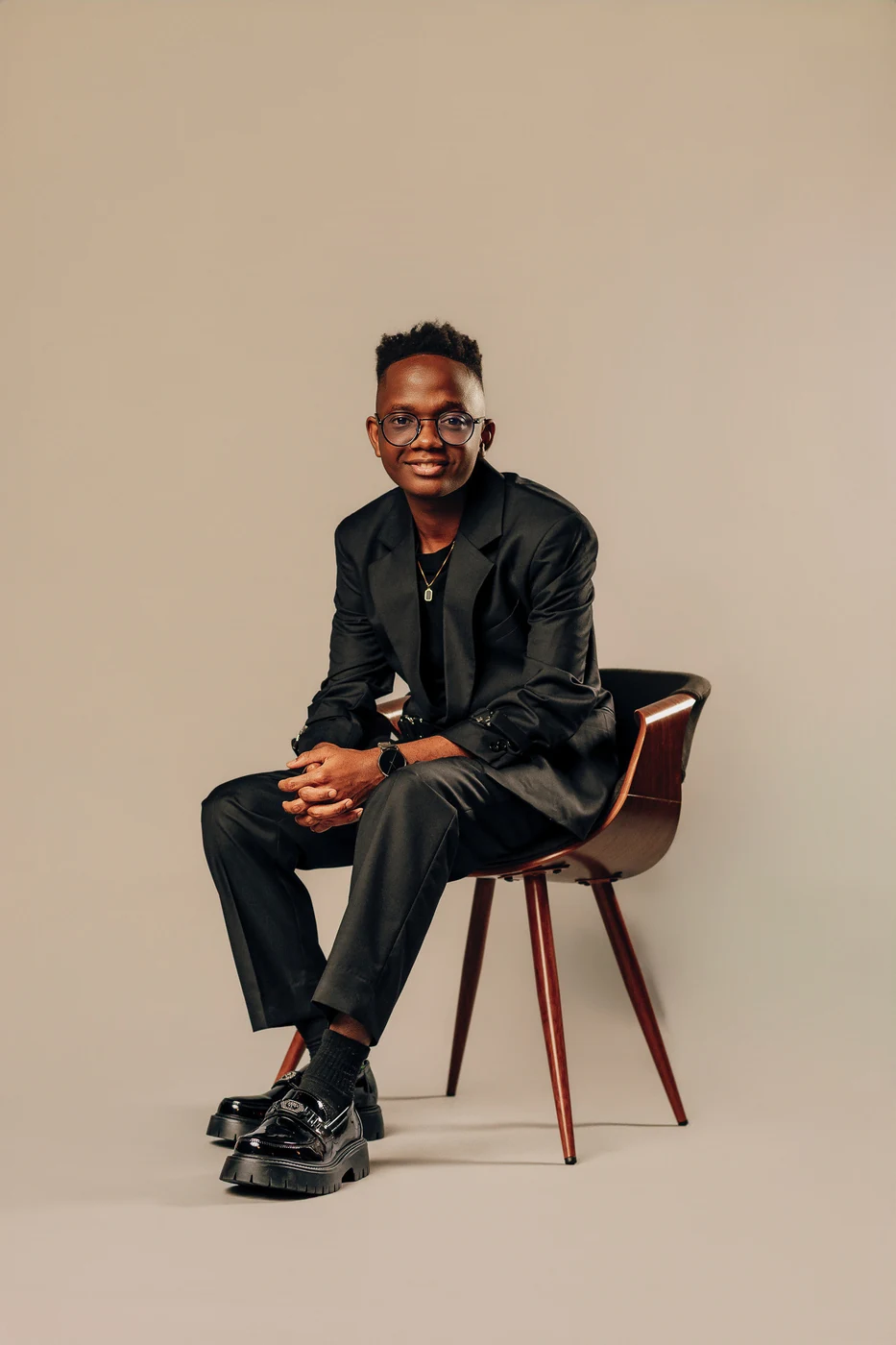 Viny seated in a wooden chair, smiling